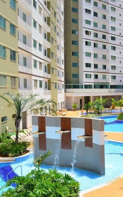 Área de lazer com mesas e piscina no hotel de Caldas Novas.